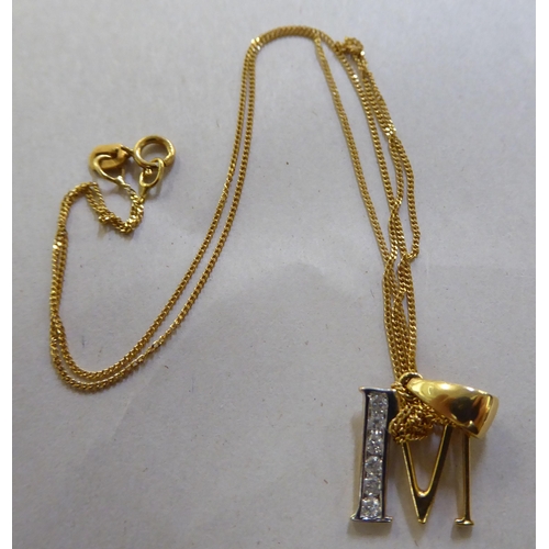 379 - An 18ct bi-coloured gold and diamond set letter M pendant, on a fine neck chain