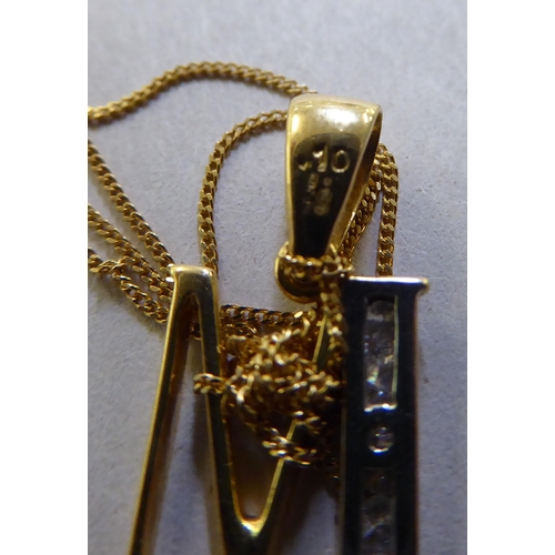 379 - An 18ct bi-coloured gold and diamond set letter M pendant, on a fine neck chain