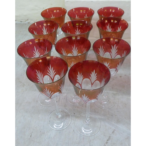 60 - A set of eleven clear and cranberry coloured, thumb moulded and foliage design pedestal wines