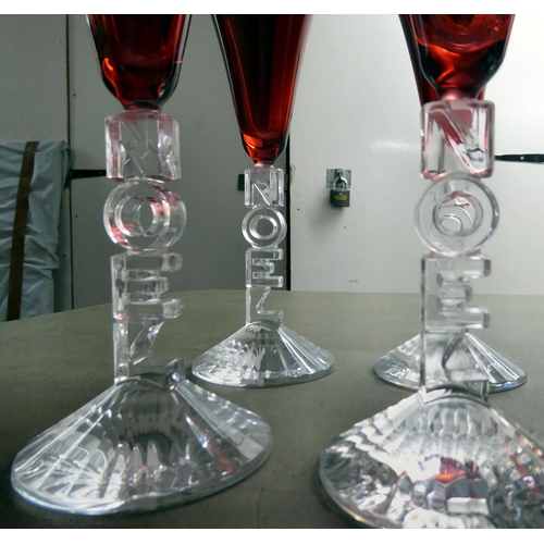 62 - A set of ten clear and cranberry coloured pedestal wines, the stems moulded to read 'Noel'