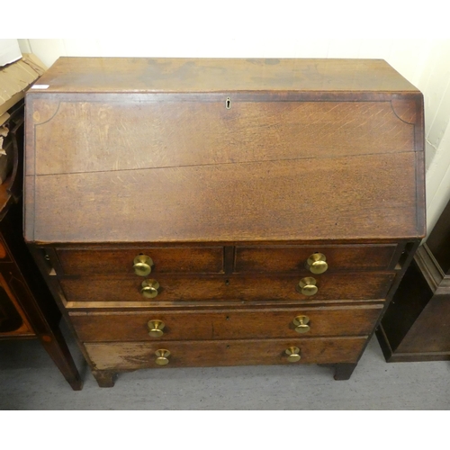 98 - A George III oak bureau, the fall flap over two short/three long drawers, raised on bracket feet&nbs... 