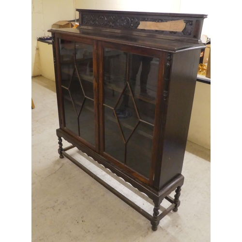 97 - A 1920s oak two door, glazed bookcase on stand  54