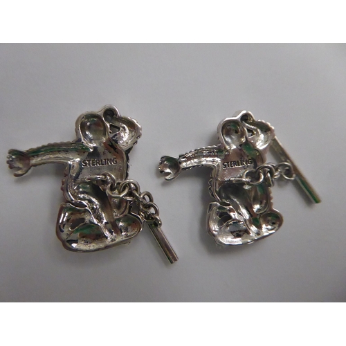 142 - A pair of Sterling silver figural, chain and tablet link cufflinks, fashioned as the Michelin Man