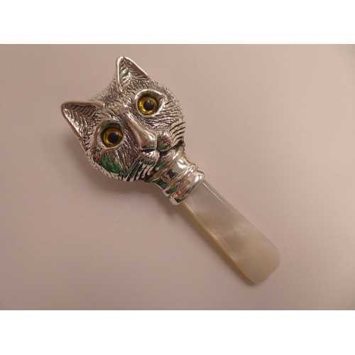 152 - A Sterling silver and abalone teether with a cat's head mount