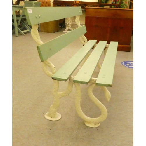 202 - A white painted cast iron, serpent design, framed garden bench with green painted slats  47