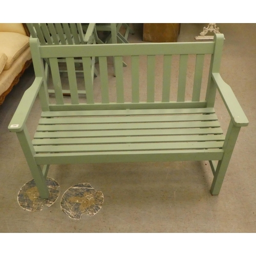 208 - A green painted garden bench, raised on square legs  51