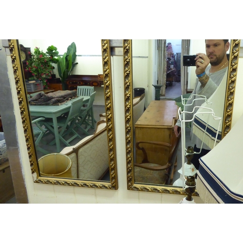 213 - A pair of mid 20thC mirrors, the plates set in moulded gilt frames  50