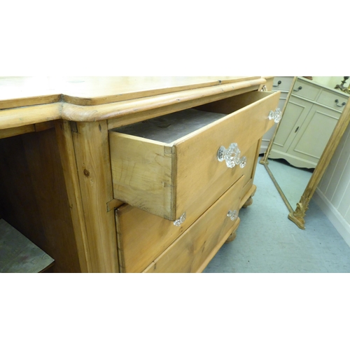 218 - An early 20thC pine breakfront sideboard with three central drawers, flanked by cupboard doors, on t... 