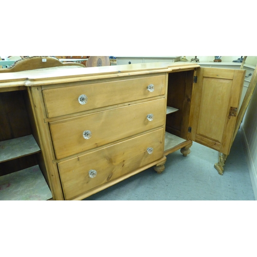 218 - An early 20thC pine breakfront sideboard with three central drawers, flanked by cupboard doors, on t... 