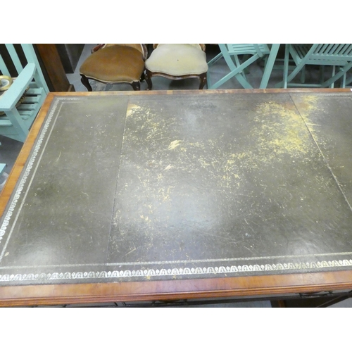 221 - A 20thC yewwood partner's desk with an arrangement of cupboard doors and drawers, on a plinth  ... 