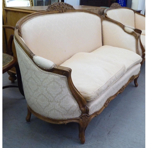 223 - A 20thC French style stained and foliate carved, beech showwood framed carved back salon settee, uph... 