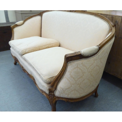 223 - A 20thC French style stained and foliate carved, beech showwood framed carved back salon settee, uph... 