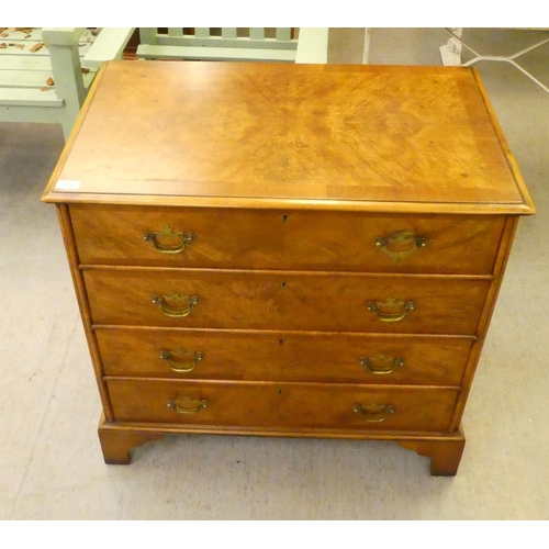 228 - A 20thC quarter walnut veneered and crossbanded, mahogany four drawer dressing chest, raised on brac... 