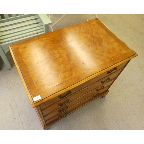 228 - A 20thC quarter walnut veneered and crossbanded, mahogany four drawer dressing chest, raised on brac... 