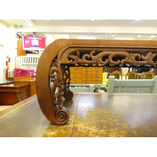 250 - An early/mid 20thC Chinese fruitwood coffee table with a carved and C-scrolled frieze, raised on car... 