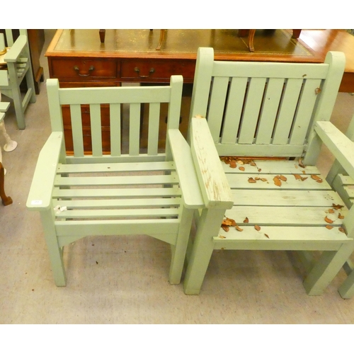 253 - Three green painted garden armchairs, raised on square forelegs