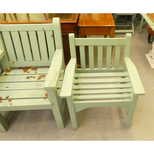 253 - Three green painted garden armchairs, raised on square forelegs