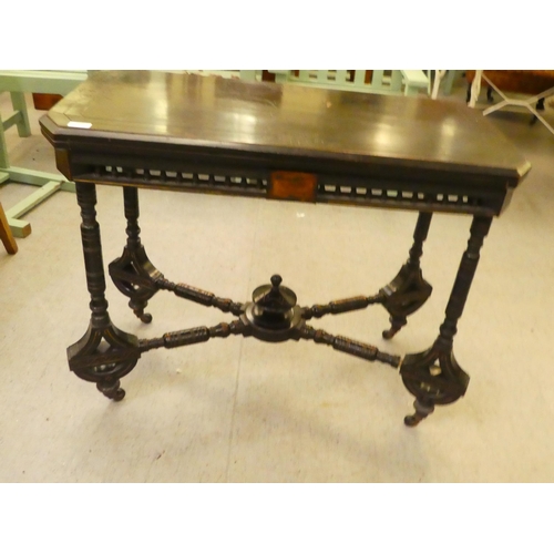 275 - An Edwardian ebonised card table, the foldover, rotating top raised on ring turned legs  37