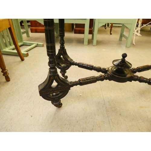 275 - An Edwardian ebonised card table, the foldover, rotating top raised on ring turned legs  37