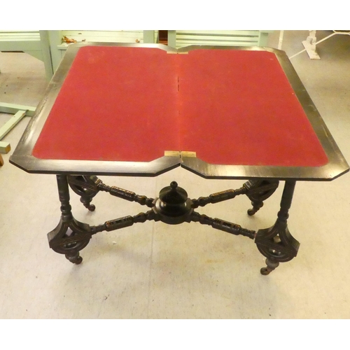 275 - An Edwardian ebonised card table, the foldover, rotating top raised on ring turned legs  37