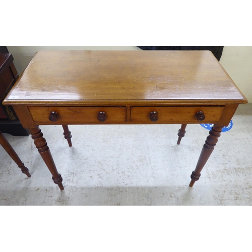 29 - A mid Victorian mahogany two drawer side table, raised on turned, tapered legs  30