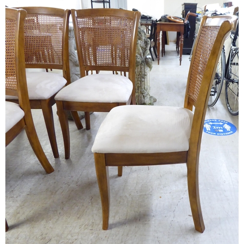 34 - A set of six modern beech framed dining chairs with caned backs and fabric upholstered seats, raised... 