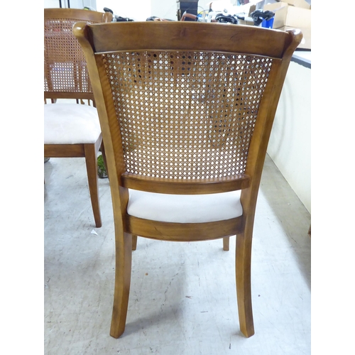 34 - A set of six modern beech framed dining chairs with caned backs and fabric upholstered seats, raised... 