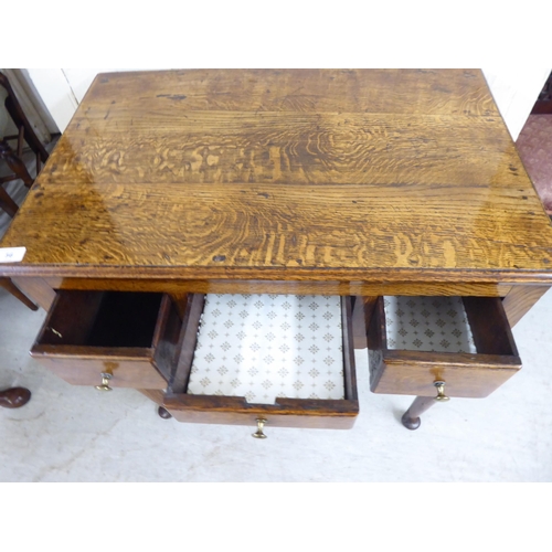 56 - A George III oak three drawer lowboy, raised on turned legs  29