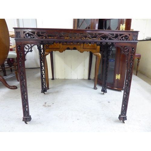 58 - An Edwardian string inlaid mahogany fret-carved, framed side table, raised on square legs and caster... 