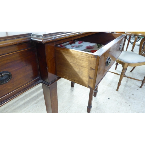 61 - An early 20thC Georgian style mahogany breakfront sideboard with a central drawer, flanked by two fa... 