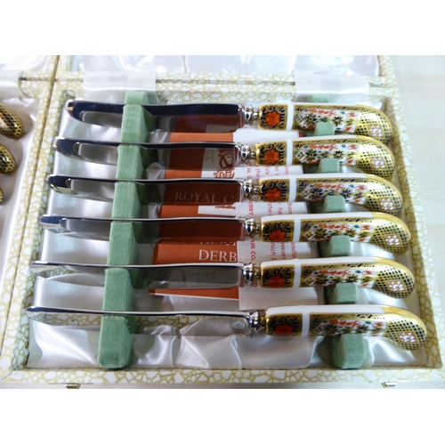 84 - A set of six Crown Derby porcelain and stainless steel knives, decorated in the Imari palette  cased... 