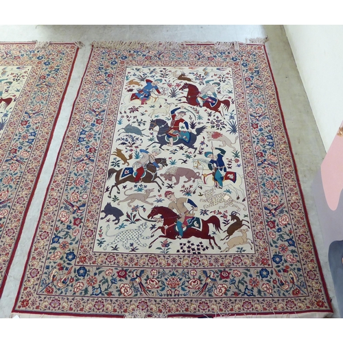 94 - A pair of Persian part woven silk pictorial rugs, depicting figures on horseback, on a hunt  59... 