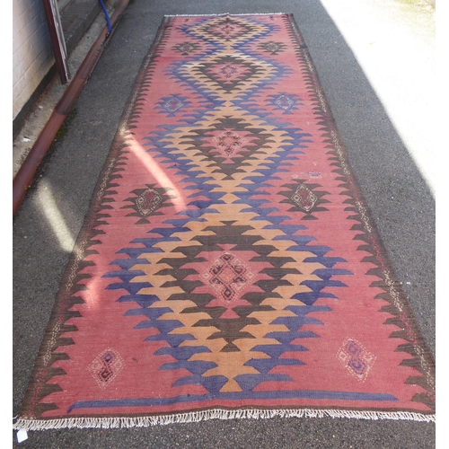 10 - A Turkish Kelim carpet, decorated with geometric patterns, on a red ground  152