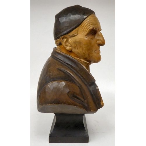 125 - A pair of Swiss carved and stained wooden busts, in the manner of Hans Huggler, depicting an elderly... 