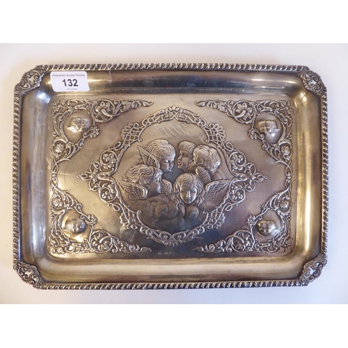 132 - A late Victorian silver dressing table tray with embossed and chased, scrolled ornament, incorporati... 