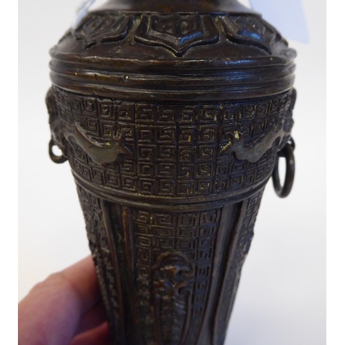 148 - A Chinese cast bronze vase of shouldered, tapered form with a narrow neck and flared rim, decorated ... 