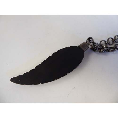 151 - A feather and diamond set pendant, on a bronze finished, ring link necklace