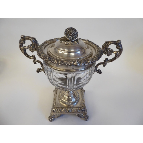 155 - A Continental white metal ice bucket with a cut glass bowl, set in a twin handled frame with a lid, ... 