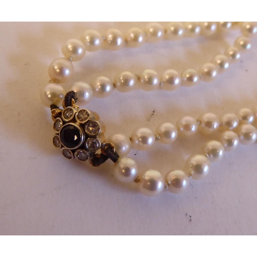 157 - A two strand pearl necklace, on a diamond set clasp