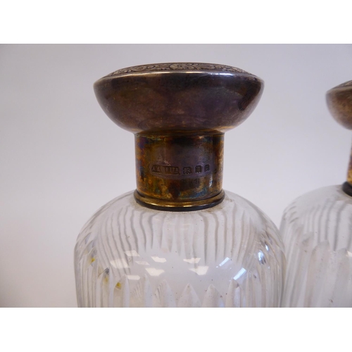 171 - A pair of cut glass cologne jars with applied silver collars and engraved silver gilt, mushroom shap... 