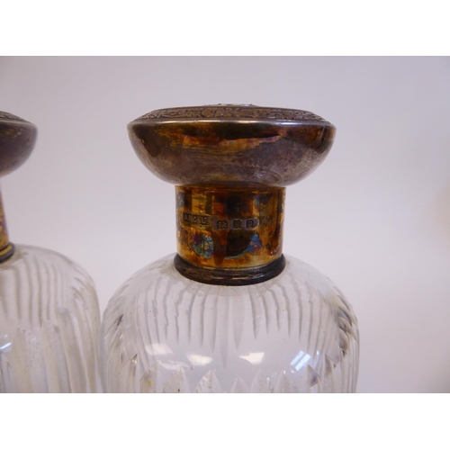 171 - A pair of cut glass cologne jars with applied silver collars and engraved silver gilt, mushroom shap... 