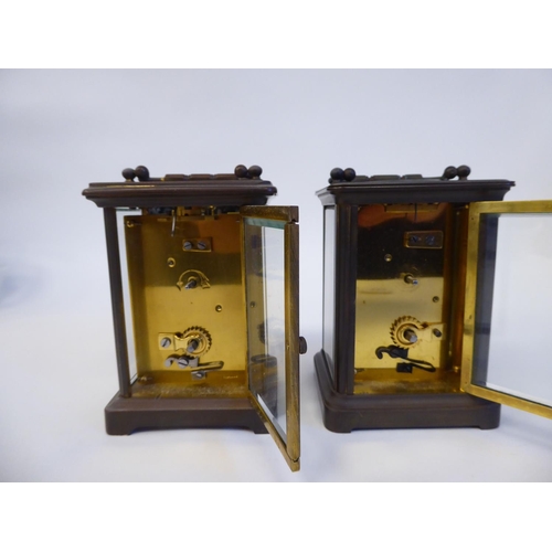 172 - Two similar brass cased carriage timepieces with bevelled glass panels and folding top handles; the ... 