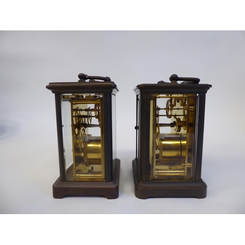 172 - Two similar brass cased carriage timepieces with bevelled glass panels and folding top handles; the ... 