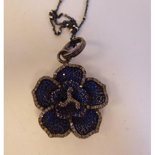 199 - A sapphire and diamond pendant, on a matching neckchain and a dog clip clasp