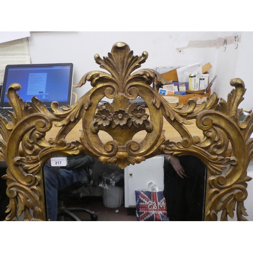 217 - A 19thC mirror, set in a floral carved and scrolled giltwood frame  40