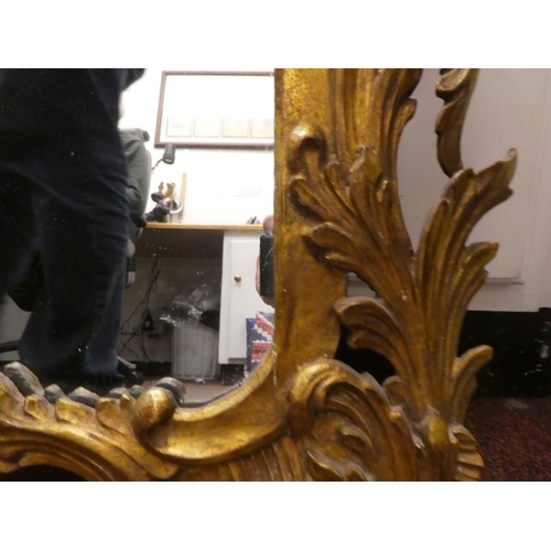 217 - A 19thC mirror, set in a floral carved and scrolled giltwood frame  40