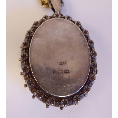 228 - Items of personal ornament: to include an oval silver pendant, decorated in ethnic taste, on a white... 