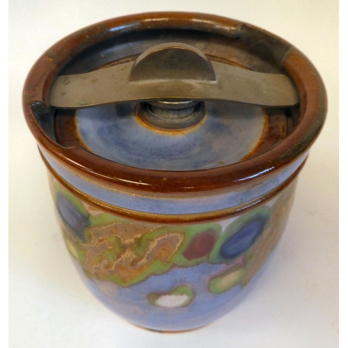 23 - A Royal Doulton stoneware tobacco jar with a rotating catch on the lid, decorated in random colours ... 