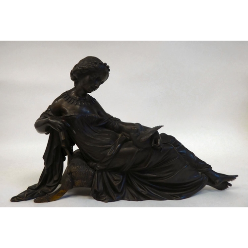 240 - A late 19thC cast and patinated bronze figure, a young woman reclining on a cushioned stool, looking... 