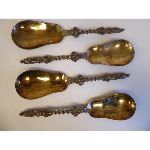 255 - A set of four silver and parcel gilt apostle spoons, the pear shaped bowls on entwined, twist handle... 